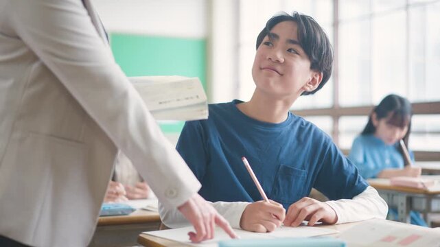先生に勉強を教えてもらう小学生
