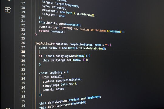 Blurry computer screen displaying lines of colorful coding language on a dark background