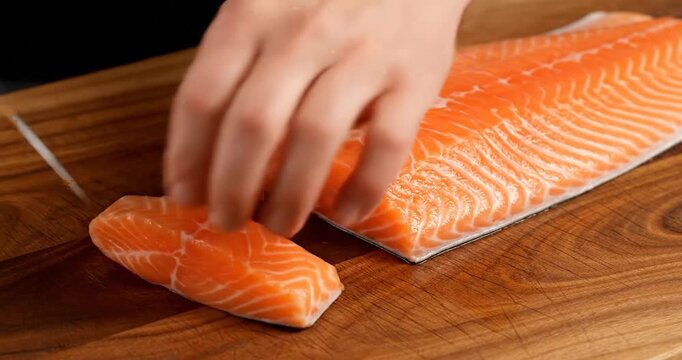 Slicing Salmon on a Wooden Board.