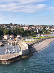 Obraz premium Aerial View of a Scottish Coastal Village Harbor and Stone Pier