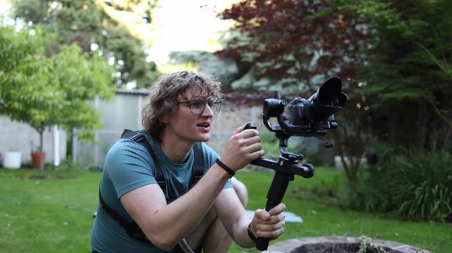 Creative videographer studies composition through a camera gimbal searching for inspiration ideas and visual storytelling concepts in an outdoor setting