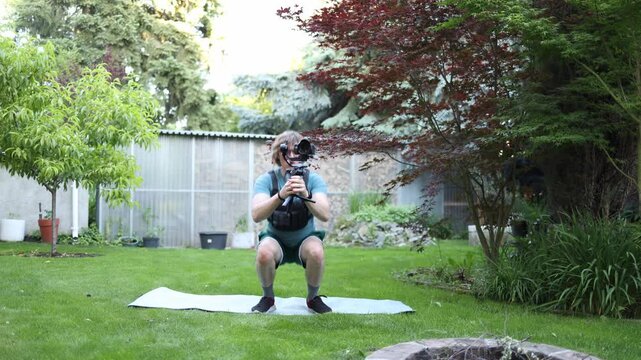 Videographer performs squats while holding a camera stabilizer developing leg strength balance and stamina Essential preparation for long hours of active filming