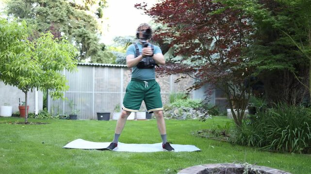 Videographer performs arm swings while holding a camera stabilizer building shoulder endurance coordination and stamina for long handheld filming sessions