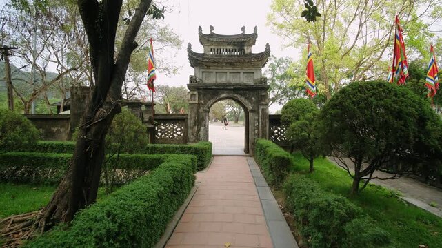 Ancient stone gate at hoa lu ancient capital in ninh binh, vietnam with traditional flags