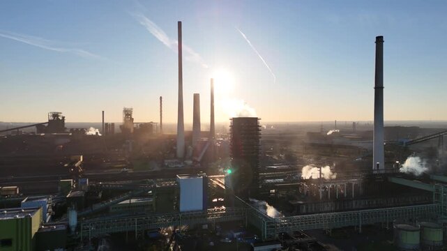 Descending above river toward sunlit coking tower