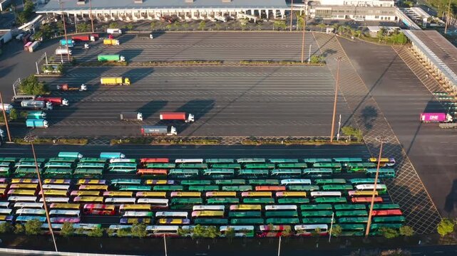 Aerial view of parked buses and trucks at large transport depot