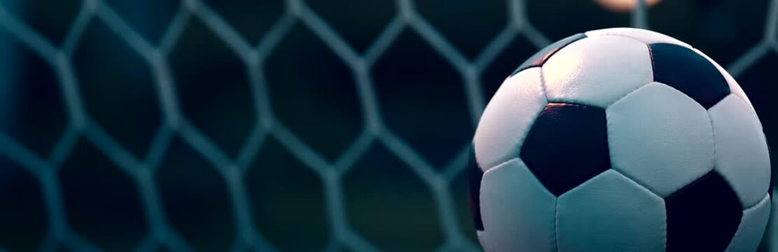 Spinning Soccer Ball on Evening Pitch with Blurred Goal Net