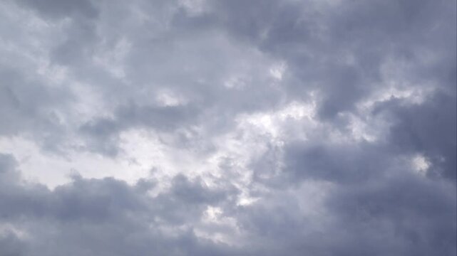 Timelapse of dramatic dark storm clouds moving across the overcast sky before rain.