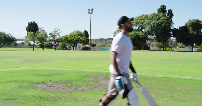 Helmeted male batter entering crease on cricket field after handshake, picking up cricket bat
