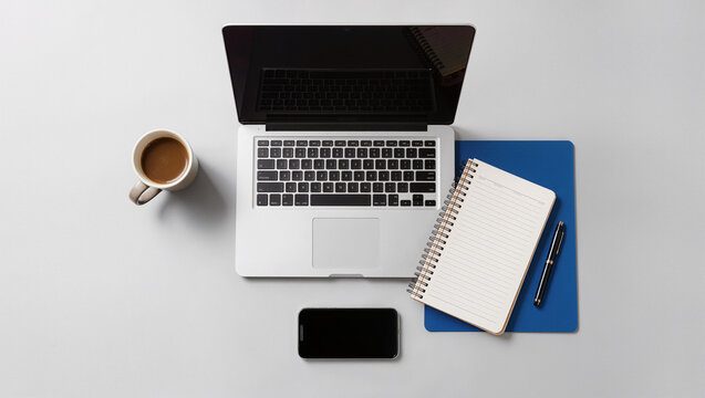 Modern Minimalist Workspace with Laptop Coffee Notebook and Smartphone