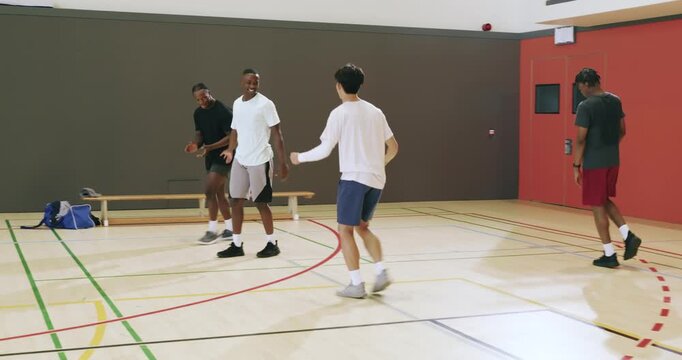 After interception ending drill, male students exchanging high-fives on basketball court