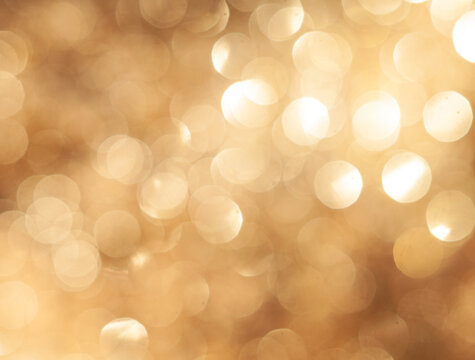 Bokeh lights shine in a warm golden hue creating an abstract background effect
