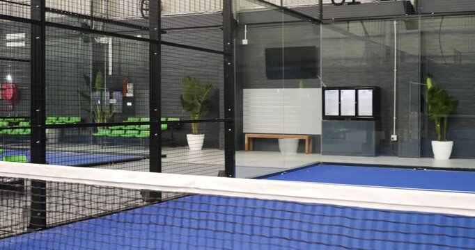 Hispanic padel player striking ball, opponent returning volley, friends clapping point