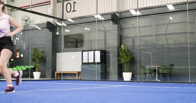 Stepping on court, female players swinging paddle striking ball, lunging, reappearing practicing