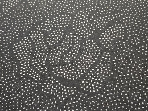 Black anti-slip fabric texture with white dotted pattern. Macro view of non-woven textile backing for rugs, carpets, and tufting crafts. High-quality grip material background.