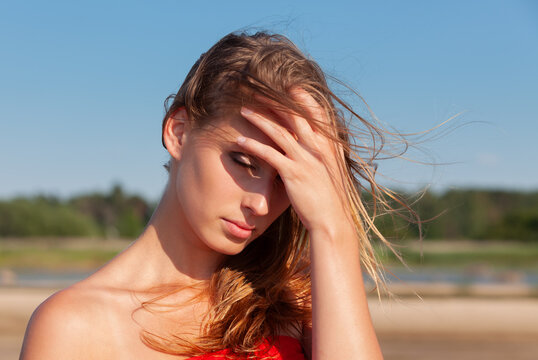 Young woman touching forehead outdoors