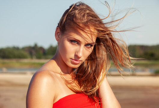 Young woman posing outdoors wearing red