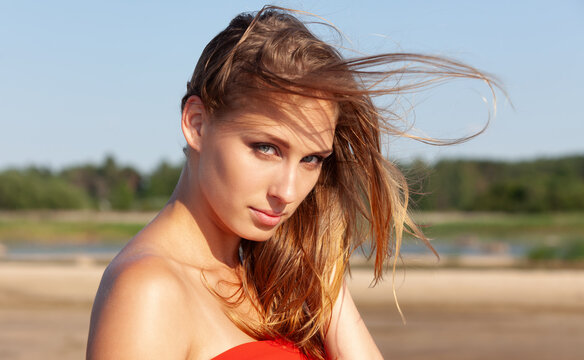 Young woman posing outdoors with windblown hair