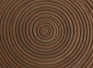 Naklejka premium Concentric circles create a topographical pattern with raised contour lines. The abstract texture features earthy brown and grey tones reminiscent of natural stone or wood grain.