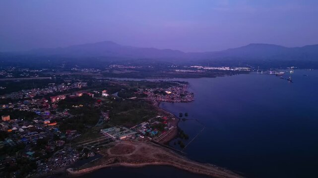Wide angle drone reveal of Calumping River, Resot snd residential area in Wawa Batangas Philippines highlighting waterfront houses, shoreline land, and boat docking areas.