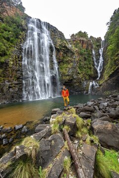 Young man standing in front of a waterfall, Lisbon Falls, long exposure, near Graskop, Mpumalanga, South Africa
