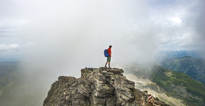 Hiker on the summit of the Hochgolling with rising fog, Schladminger H&ouml;henweg, Schladminger Tauern, Schladming, Steiermark, Austria