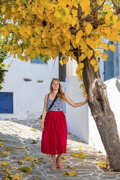 Young woman with red dress in the old town of Lefkes, Paros, Cyclades, Greece