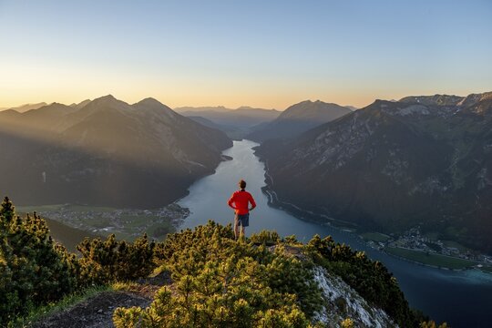 Sunset, young man looking over mountain landscape, view from the top of the B&auml;renkopf to the Achensee, left Seebergspitze and Seekarspitze, right Rofangebirge, Tyrol, Austria