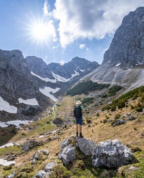 Hiker standing on a stone, hiking trail to the Rote Fl&uuml;h, in the background Gamskar and rocky peaks, Sonnenstern, Tannheimer Berge, Allg&auml;u, Bavaria, Germany