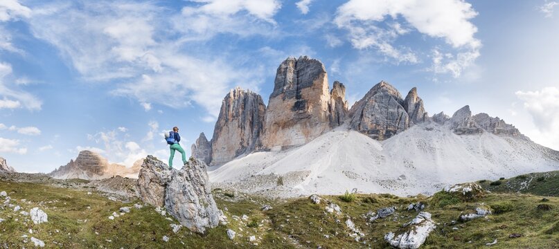 Hiker stands on rocks, north faces of the Three Peaks of Lavaredo, Sesto Dolomites, South Tyrol, Trentino-South Tyrol, Alto-Adige, Italy