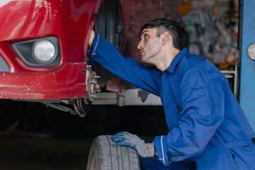 Fototapeta premium Auto mechanic worker changing car tire in auto workshop garage, Vehicle tyre maintenance service