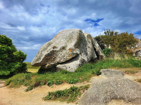 Spektakul&auml;re Granitfelsen pr&auml;gen den Plage du c'hi du bei Meneham. Die raue Natur der bretonischen K&uuml;ste zeigt sich hier in ihrer vollen, windgepeitschten Pracht unter blauem Wolkenhimmel.