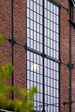Industrial architecture fills the frame as glass windows and brick facade lines create vertical urban building texture in daylight