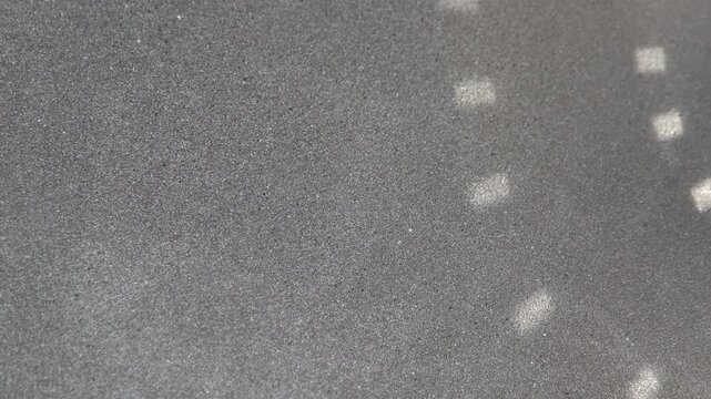 Gray background with glare from a disco ball. Texture of Dark Grey Foam Rubber surface