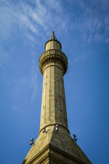 Obraz premium Ornate sandstone minaret with carved balcony reaching towards blue sky in Baku, Azerbaijan, serene and historic.