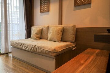 Fototapeta premium Cozy Modern Living Room Features Comfortable Sofa Bed With Cushions Next To Large Window