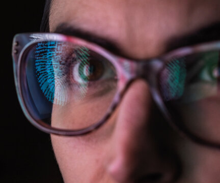 Woman with a reflection of a finger print on her glasses to represent identity and access