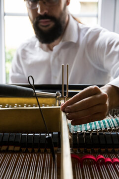 Piano tuner tuning grand piano
