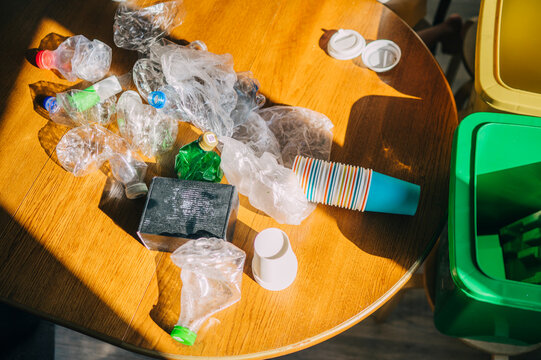 Household waste sorting with plastic and cardboard on wooden table