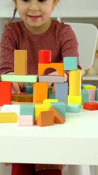 A child plays with wooden blocks. Selective focus.