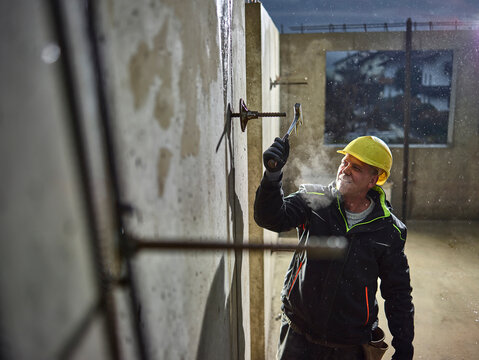 Construction worker fitting with hammer the iron rod