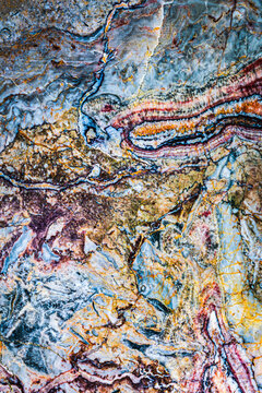 Natural stone surface showing lines of different colors and textures in a layered design