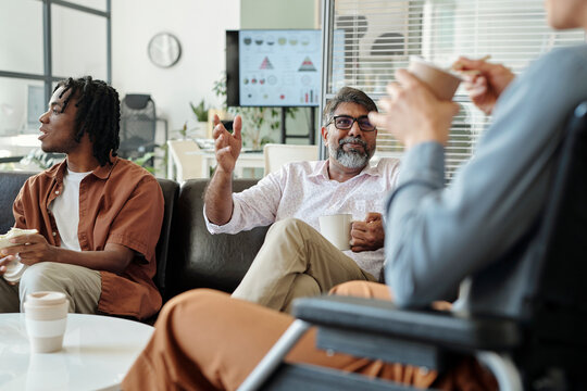 Colleagues having a coffee break and engaging in conversation in an inclusive office setting