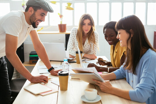 Smiling colleagues working together at desk in office
