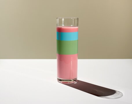 Glass filled with layered colorful liquid showing a statistic