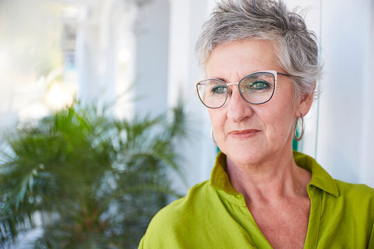 Content woman with glasses contemplating the future outdoors