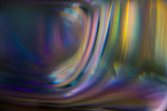 Abstract analog film burn texture with rainbow light leak, grain and iridescent refractions. Vintage photographic overlay ideal for retro effects, cinematic edits and creative photo filters.