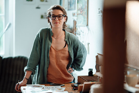 Female illustrator wearing eyeglasses at home office