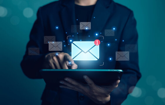 Email marketing and digital communication concept featuring a business professional using a tablet with incoming message notifications. Represents email management, online messaging.