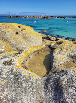 Die K&uuml;ste am Plage de Roc'h ar Gonc beeindruckt mit gelb leuchtenden Flechten auf den Granitfelsen und kleinen Gezeitent&uuml;mpeln vor dem t&uuml;rkisblauen Meer.